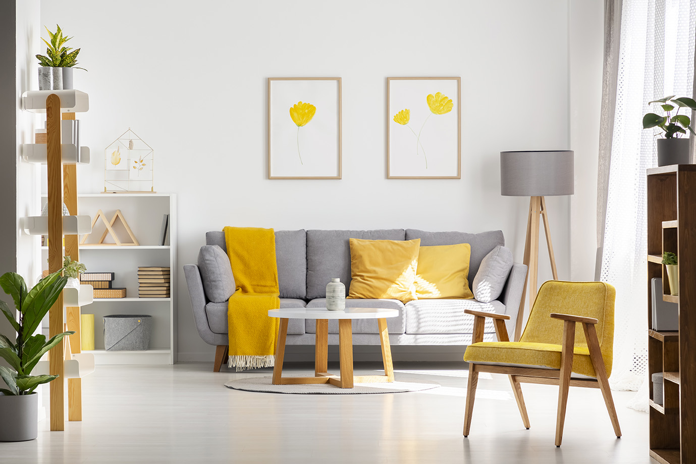 Yellow wooden armchair in bright living room interior with poste